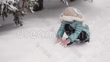 冬天公园里的<strong>小女孩</strong>雕刻<strong>雪人</strong>。 从天而降的雪。